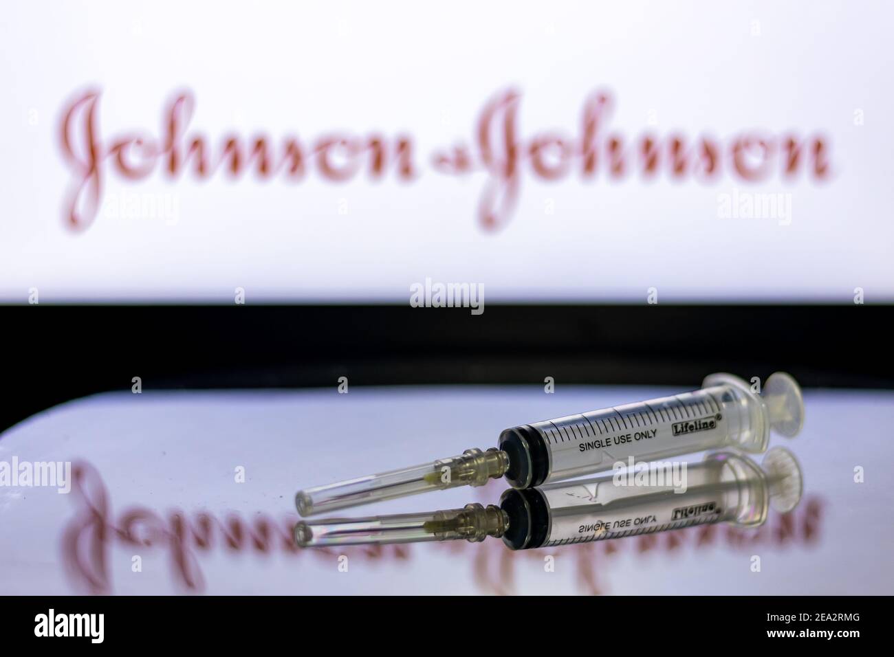 Kathmandu, Nepal - February 7 2021: Syringe Injection placed against Johnson and Johnson logo. JnJ coronavirus vaccine will work with only 1 dose as c Stock Photo