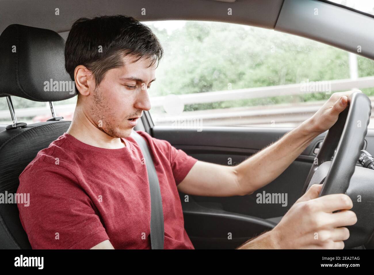 man driving the car fell asleep and does not control the road situation. Drugged with alcohol or insomnia concept. Car crashes and deaths Stock Photo