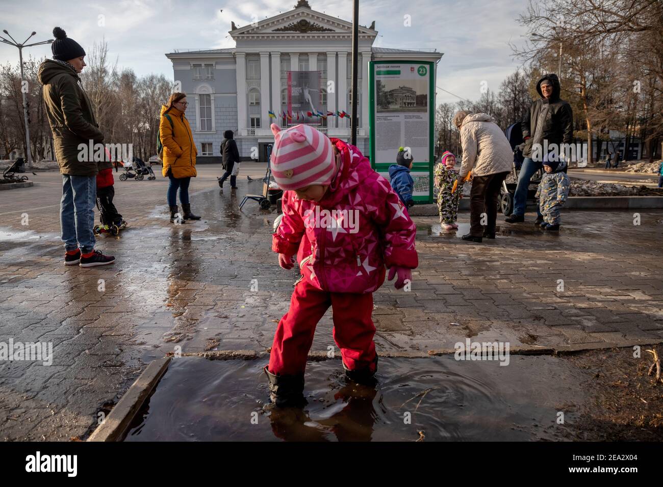 Parents walk with their children after the rain at the square near the Perm Academic Opera and Ballet Theater in the center of Perm city, Russia Stock Photo