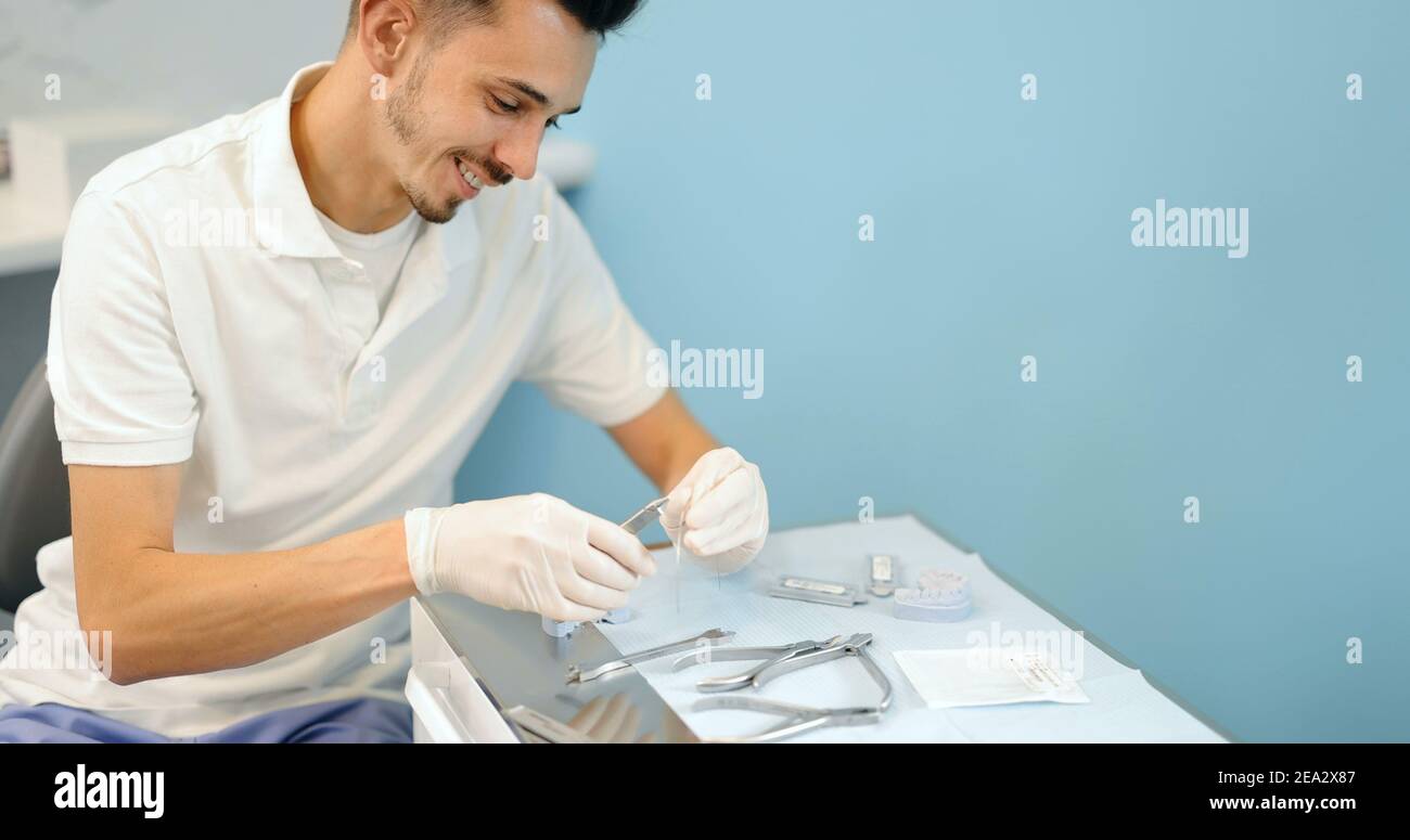 Dental technician working with a model of teeth and dental braces Stock ...