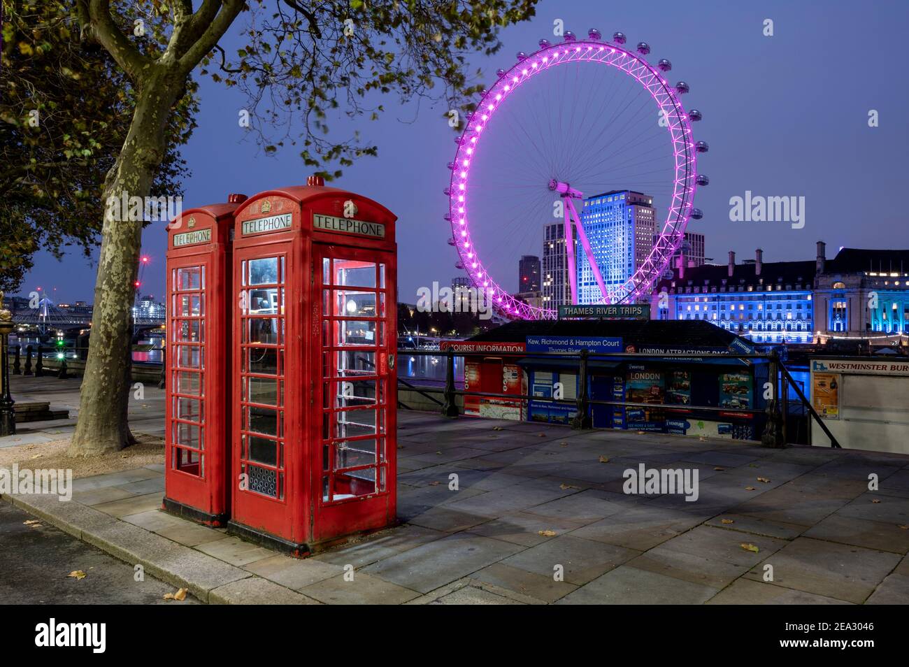 The London Eye at night with two red telephone boxes, London Stock Photo