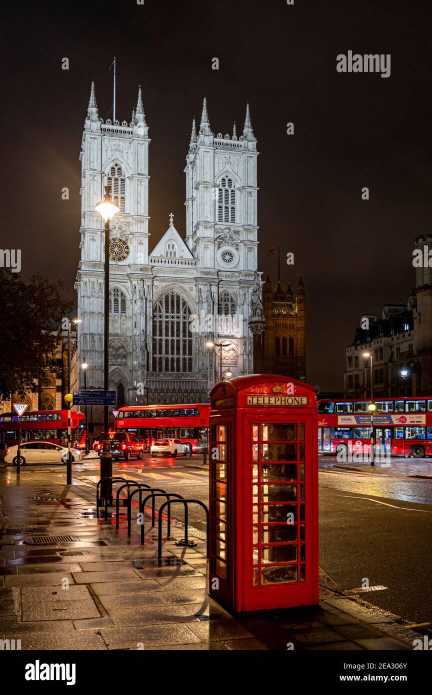 Westminster Abbey at night with red telephone box and London buses, London Stock Photo