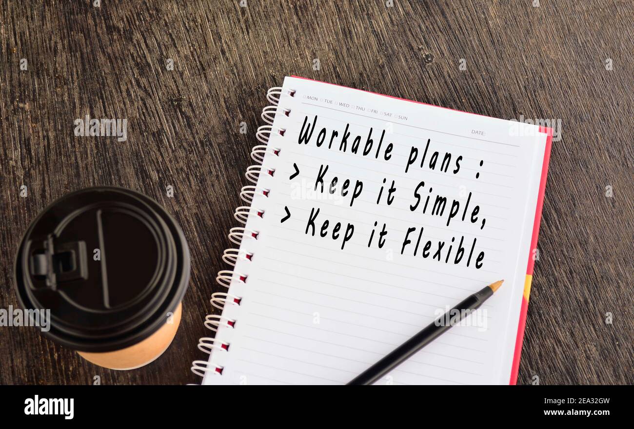 Text on notepad with background of cup of coffee and a pen on wooden table Stock Photo