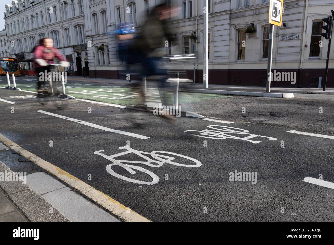 Cardiff, Wales - February 3rd 2021: Two cyclists ride through Cardiff City Centre, on one of Cardiff Councils newly developed cycleways. Stock Photo