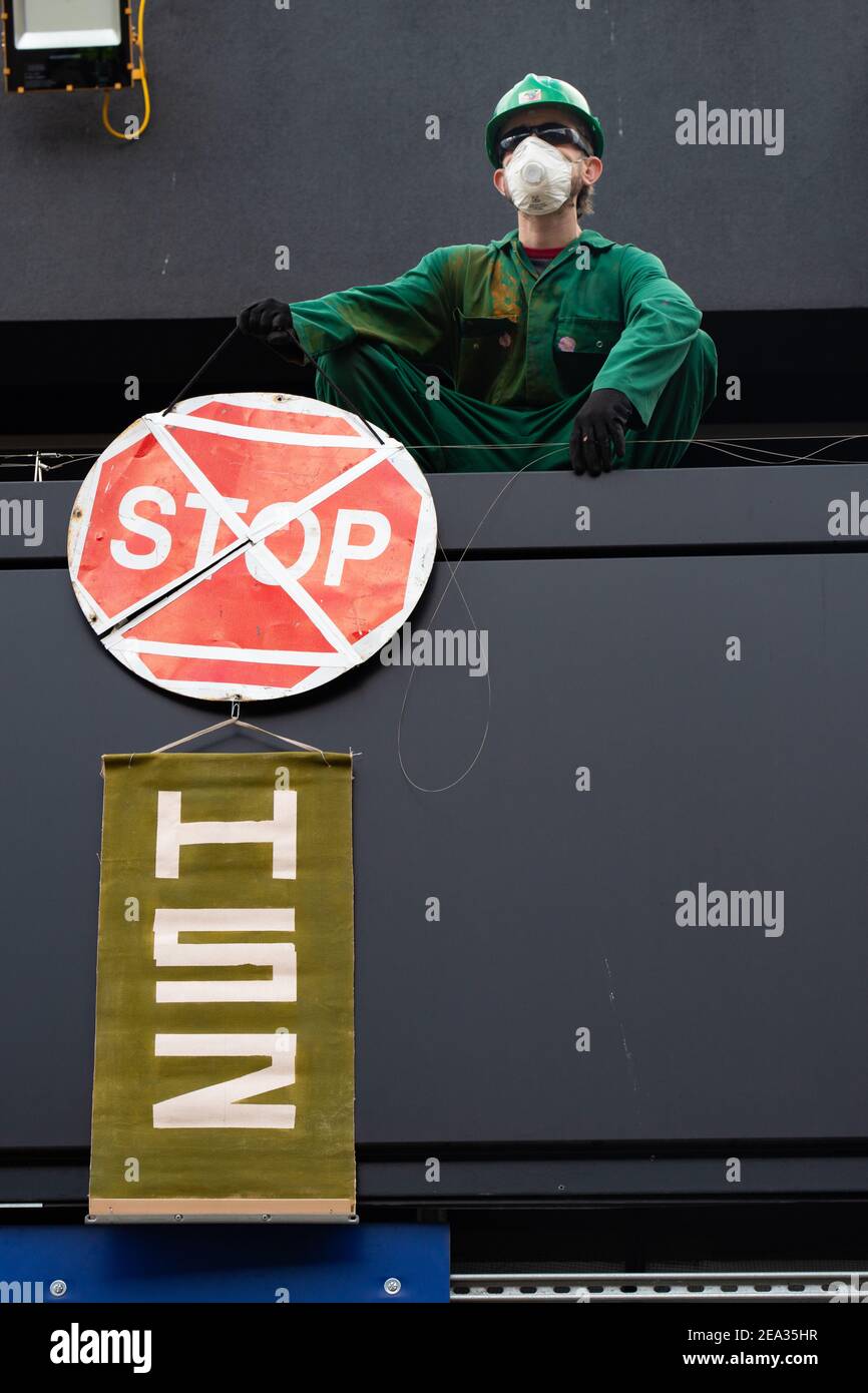 A male activist holding a placard climbs onto the roof of Euston Station, London UK in protest at the HS2 project, 29th January 2021. Stock Photo