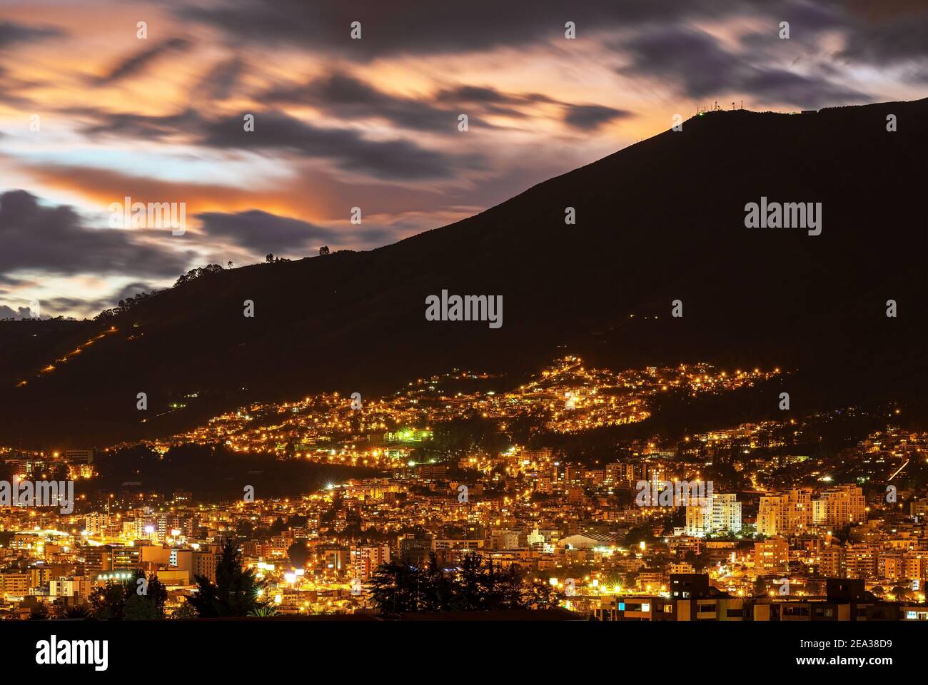 Aerial night cityscape of Quito city at sunset with Pichincha Volcano