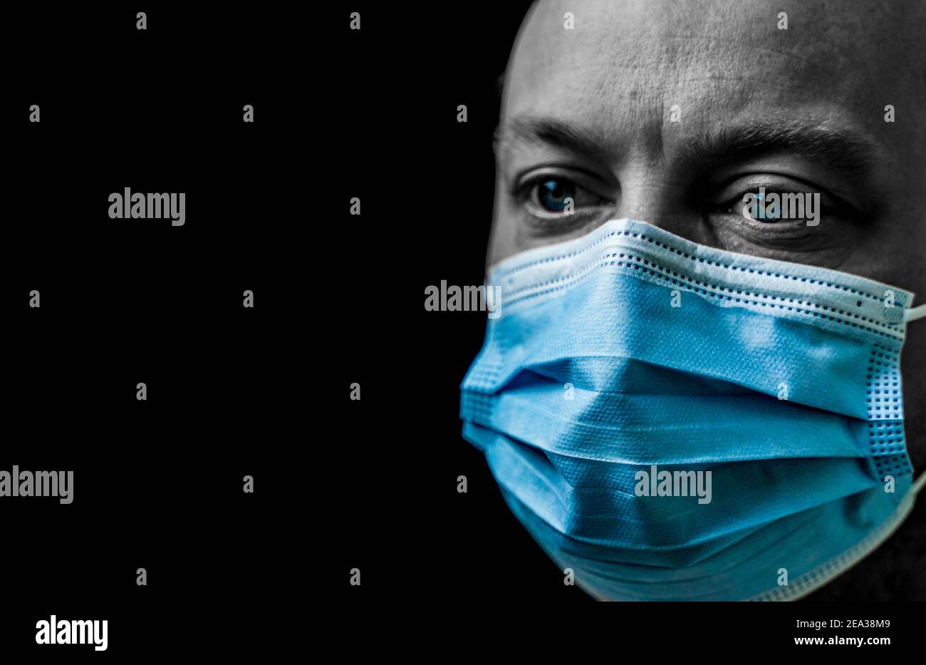 Sick man with bright blue eyes wearing a facemask, portrait isolated on ...