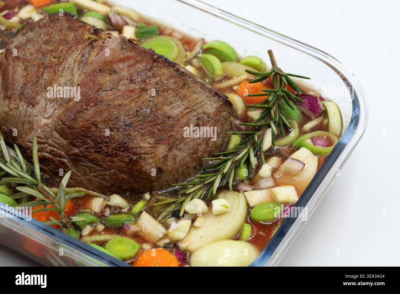 Beef steak with twig rosemary and vegetables in glass bowl isolated on white background Stock Photo