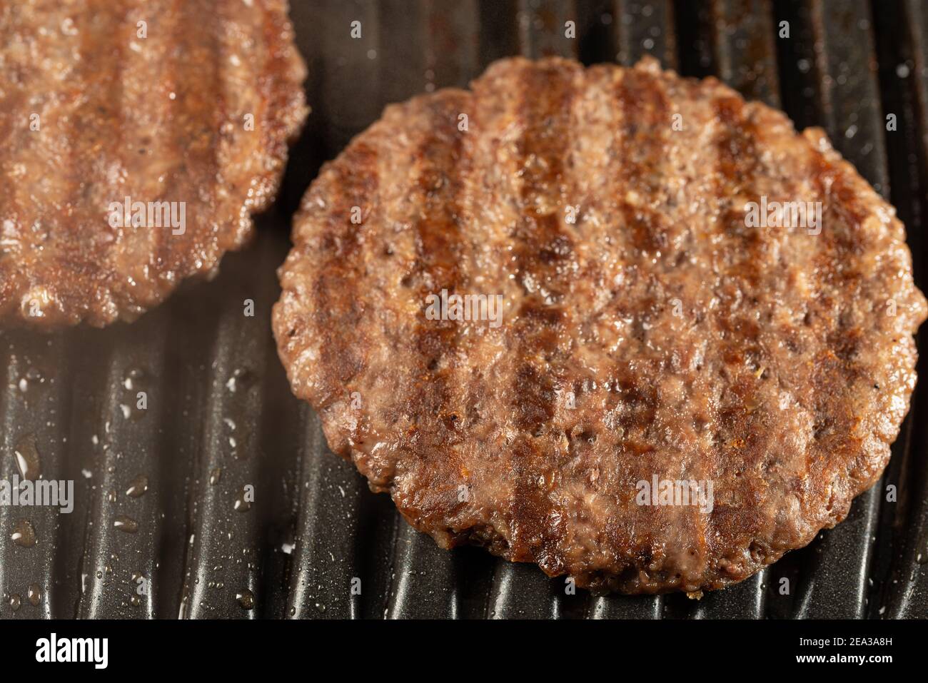 Fresh beef cutlets on a grill. Cooking a burger at home. Delicious and