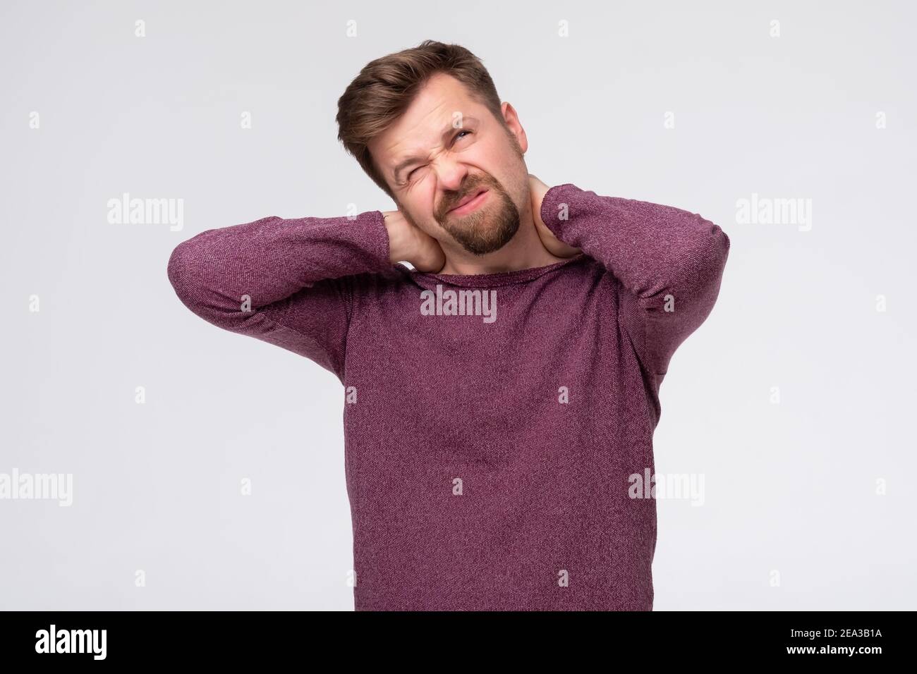 Young handsome man suffering neck pain due to sedentary lifestyle. Osteochondrosis or hernia concept Stock Photo