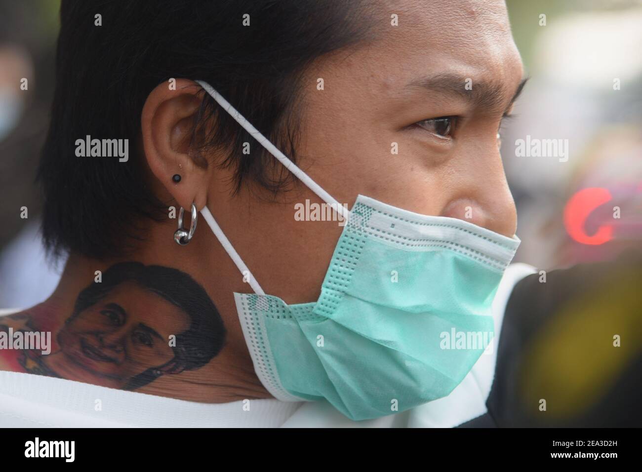 A protester with a tattoo of the detained civilian leader Aung San Suu Kyi during the demonstration against the military coup.Citizens of Myanmar protest against the military coup in Myanmar outside United Nations venue in Bangkok. Stock Photo