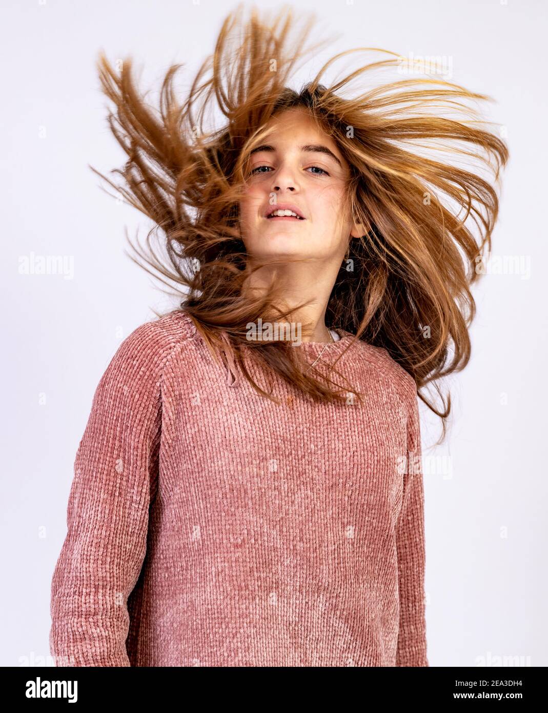 Young Girl shaking her head with hair ruffled by the wind Stock Photo