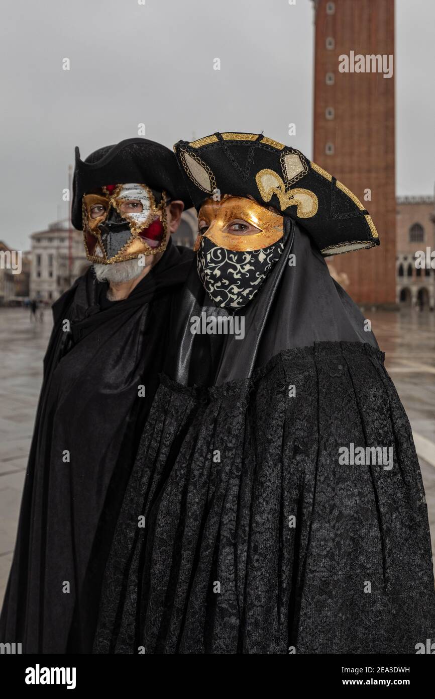 Couple wearing elegant Bauta costumes in Venice during covid 19 restrictions in February 2021 Stock Photo