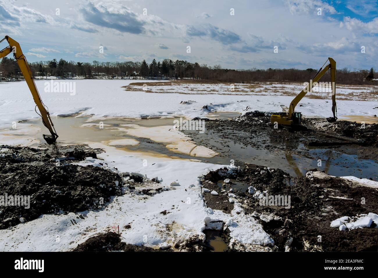 Excavators dredge and clean up a lake the winter snow of lake bottom Stock Photo Alamy