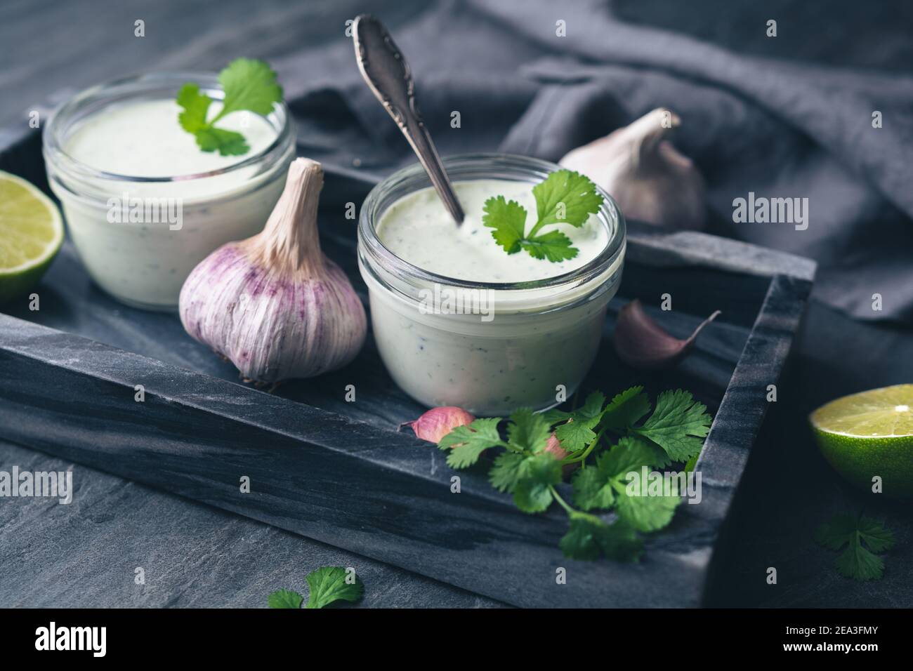 Cilantro garlic sauce with lime juice and olive oil in a glass jar Stock Photo