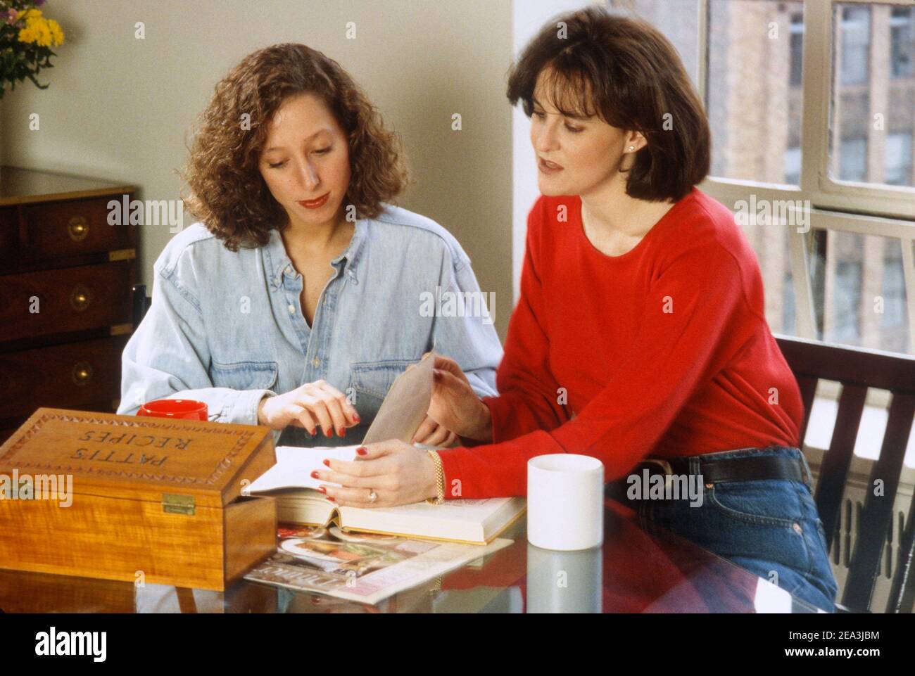 Two young women compare cooking recipes, USA Stock Photo