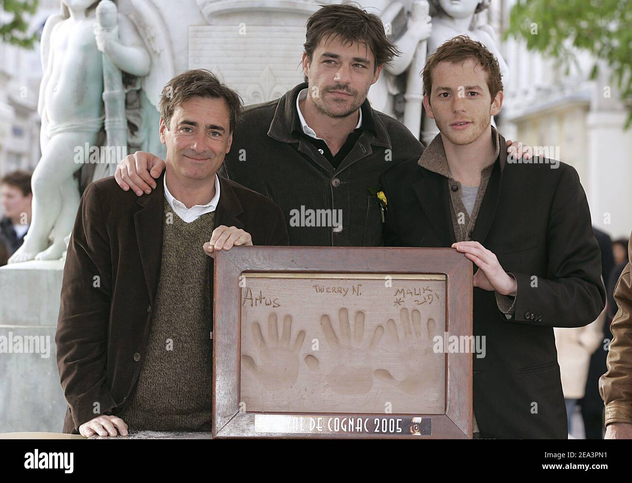 French director Artus de Penguern, French actors Thierry Neuvic and Malik Zidi pose with their handprints in clay during the 23rd Cognac Detective Film Festival in Cognac, France, on April 9, 2005. Photo by Patrick Bernard/ABACA. Stock Photo