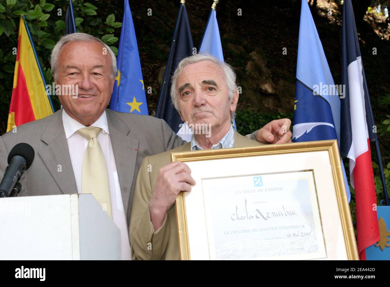 French singer Charles Aznavour (r) receives from Cannes' mayor Bernard Brochand, the medal of Citizen of Honor and the palm of the city during a ceremony held at the Villa Domergue in Cannes, France on May 18, 2005. Photo by Benoit Pinguet/ABACA Stock Photo