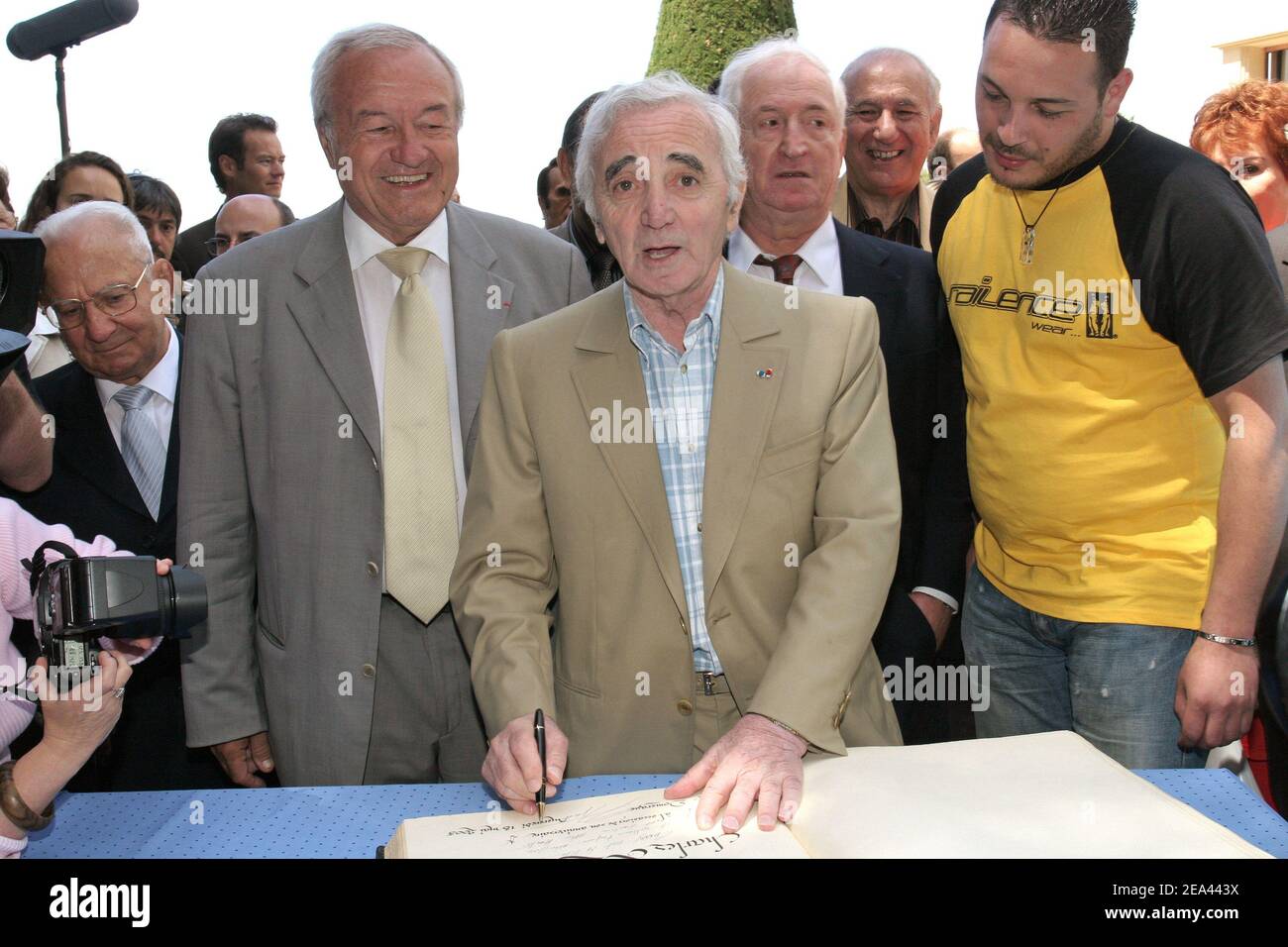 French singer Charles Aznavour (C) receives from Cannes' mayor Bernard Brochand (L), the medal of Citizen of Honor and the palm of the city during a ceremony held at the Villa Domergue in Cannes, France on May 18, 2005. Photo by Benoit Pinguet/ABACA Stock Photo
