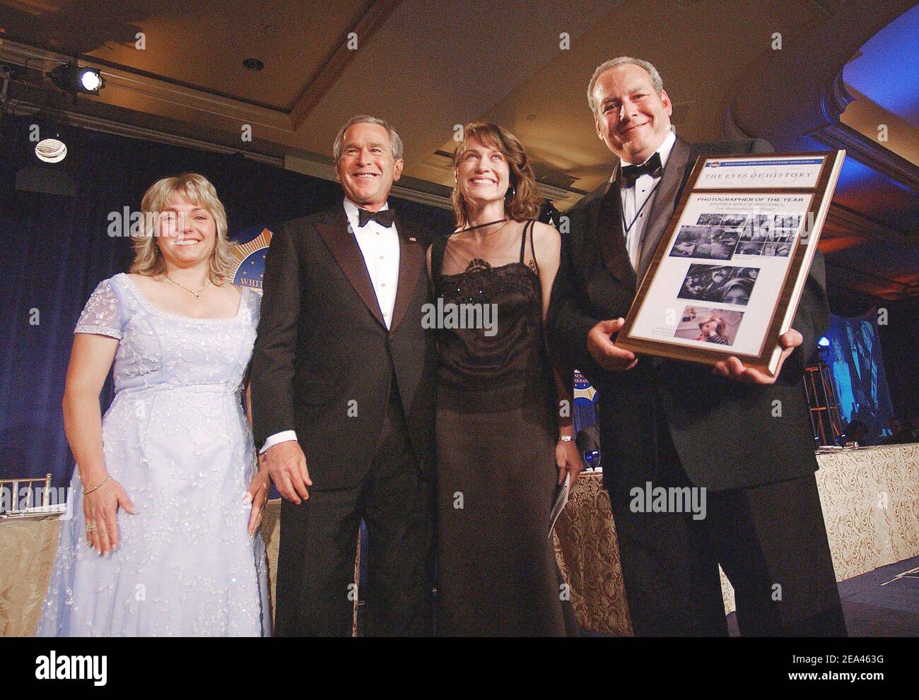 'U.S. President George W. Bush poses with Photographer of the year Andrea Bruce Woodall (washington Post), Steve Heiner, General Manager Digital SLR systems, Nikon and WHNPA President Susan Walsh during the annual White House News Photographers' Association ''Eyes of History'' gala dinner, in Washington, DC, on May 21, 2005. President Bush gave a humorous slide show of his own during the event. Photo by Olivier Douliery/ABACA' Stock Photo