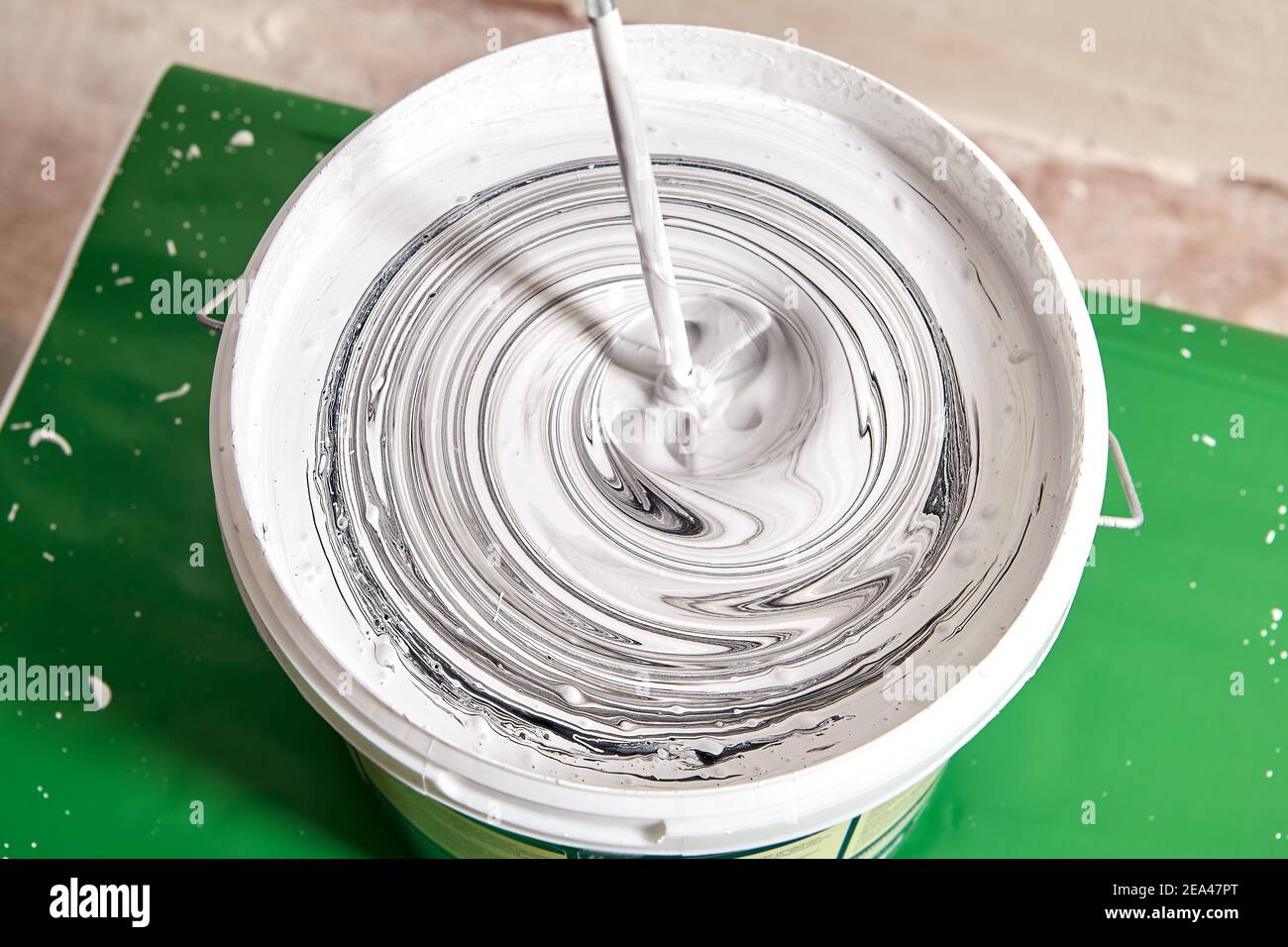 House painter mixes black and white paint to get a