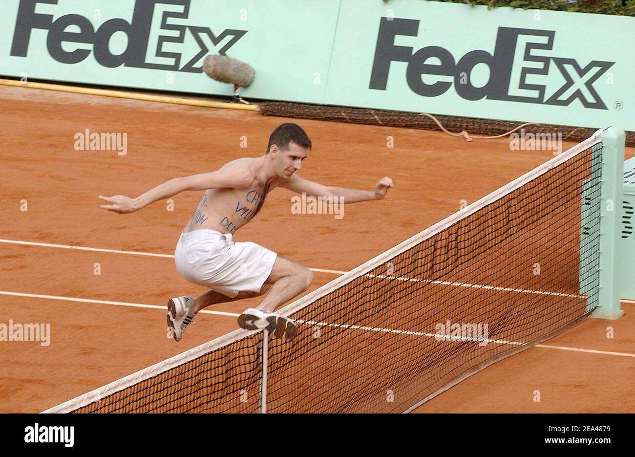 A protester bearing the slogan 'Chirac, Villepin, Resign' on his chest runs  across the court during the quarter-final match between France's Mary  Pierce and top seed Lindsay Davenport of the U.S in