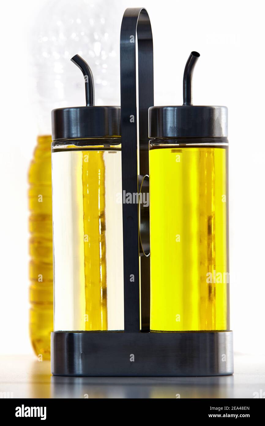 Set of two bottles with narrow pour spout for holding vinegar or cooking oil in metal holder