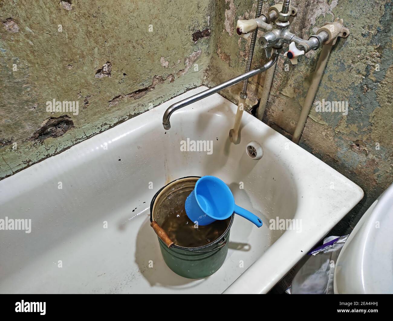 Water drips from faulty tap in dirty bathroom. Old faucet in bathroom