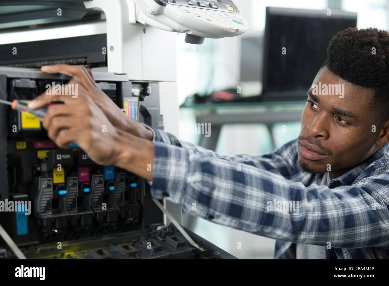 technician using a tablet to fix a printer Stock Photo