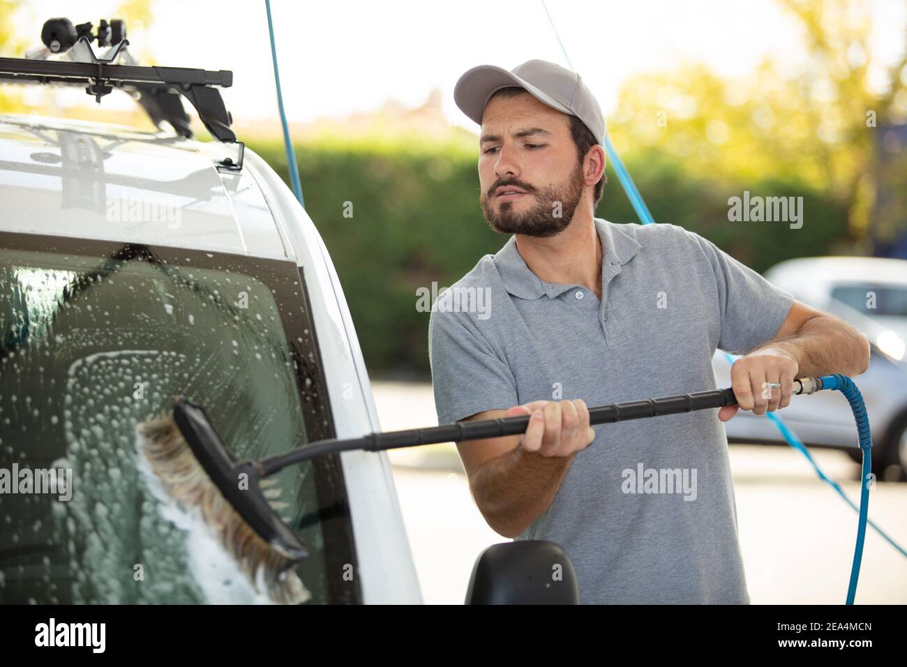 young man cleaning the windows on his car from outside Stock Photo Alamy