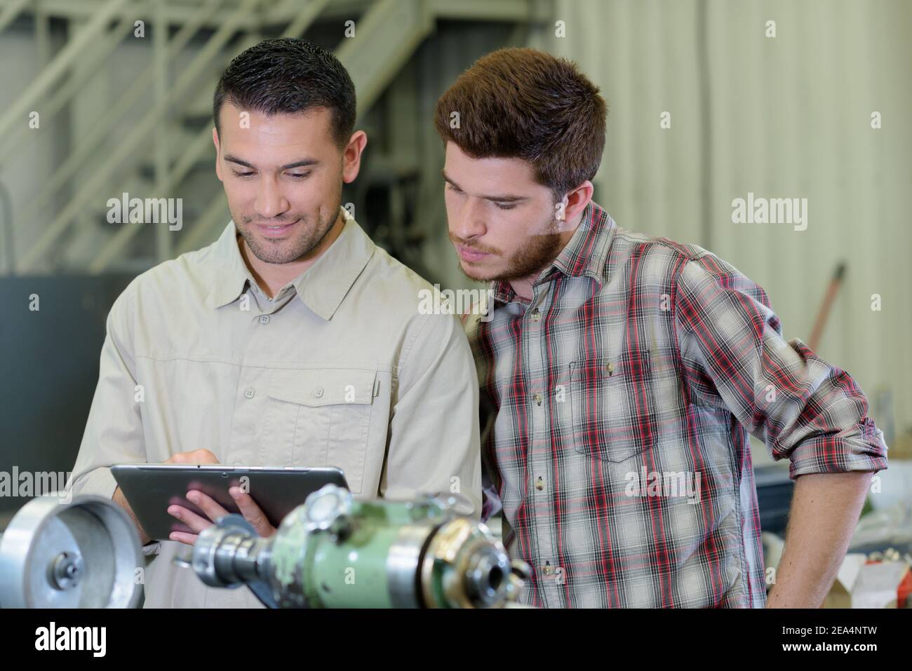 male engineer with apprentice checking stock levels Stock Photo - Alamy
