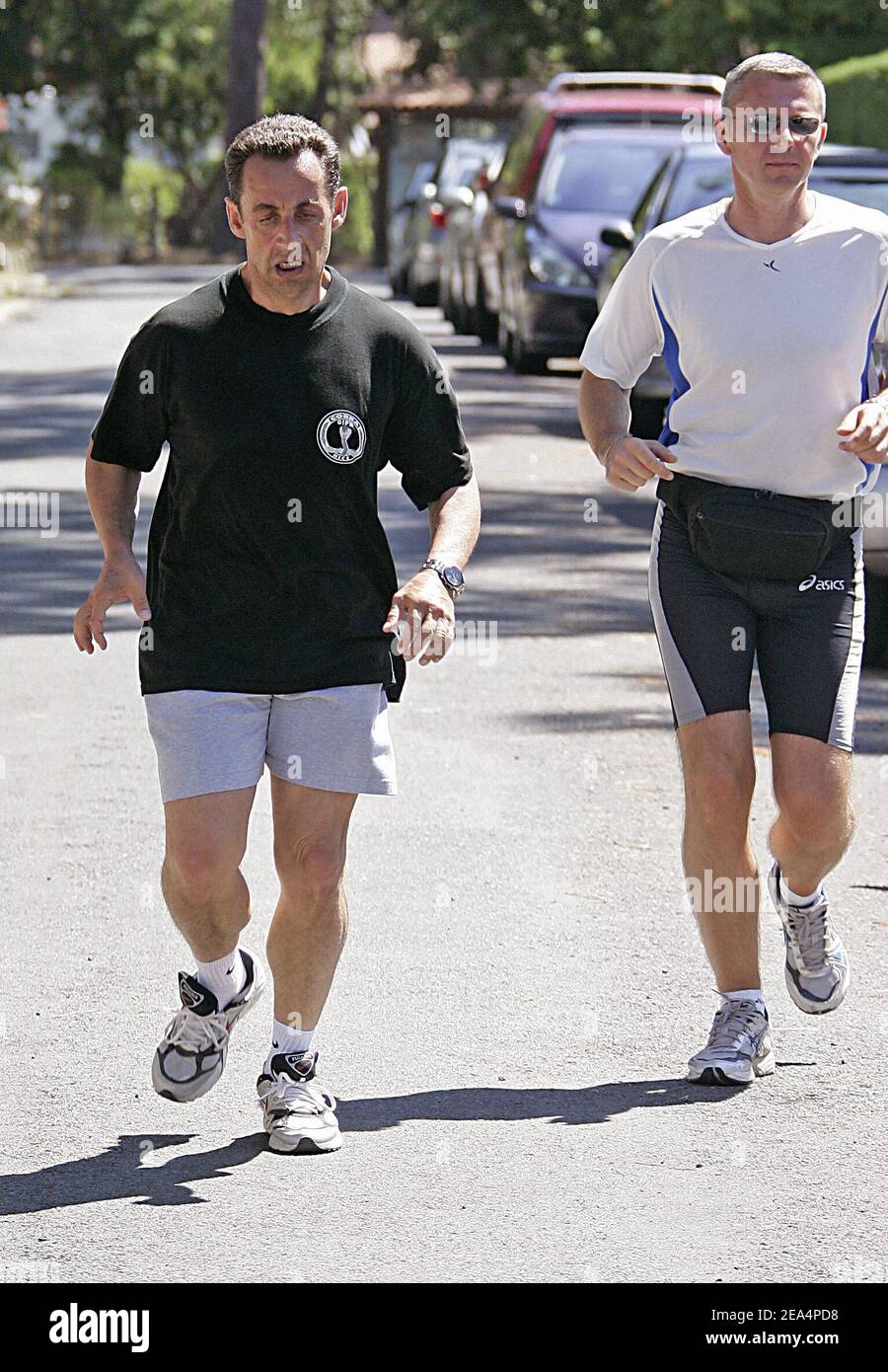 French Interior Minister Nicolas Sarkozy flanked by two bodyguards makes a  10 km jogging through the dunes around Le Pyla, southwestern France, on  August 3, 2005, on the first day of a