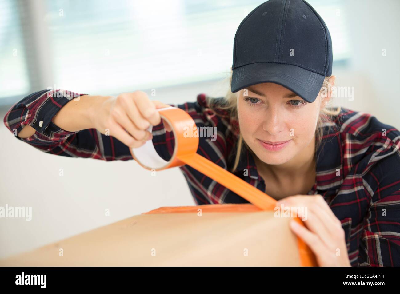 woman packing cardboard boxes using tape dispenser Stock Photo Alamy
