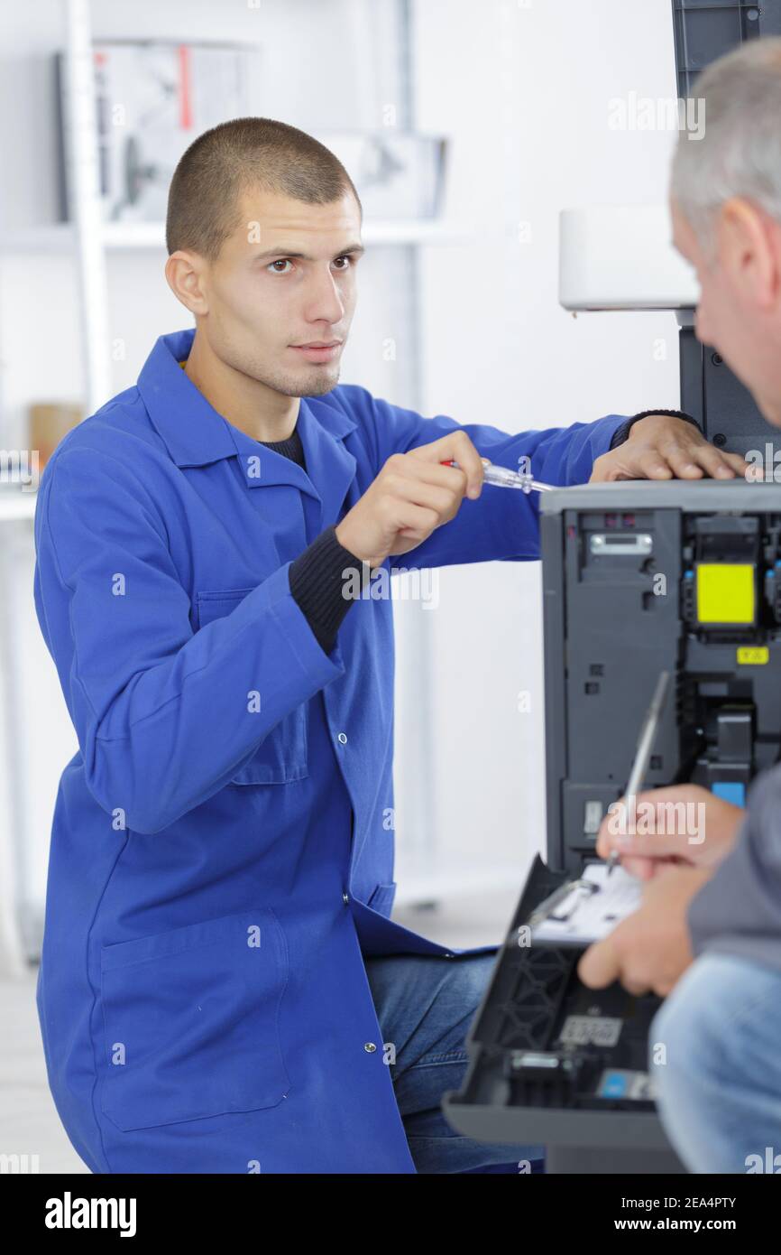 portrait of apprentice fixing a printer Stock Photo - Alamy