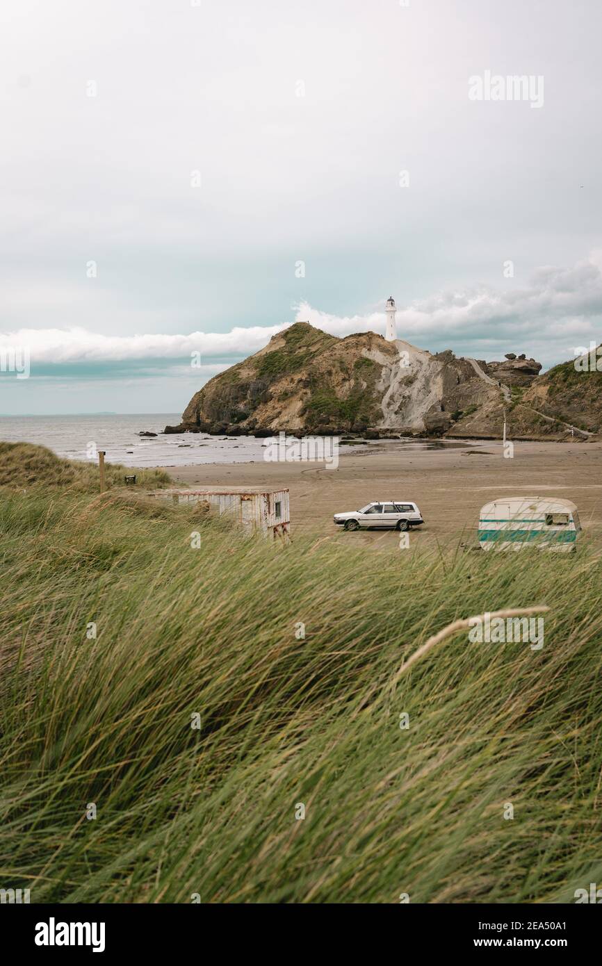 Castle point beach on a summer day and a car and a caravan park on the sand.New Zealand. Vertical photography Stock Photo