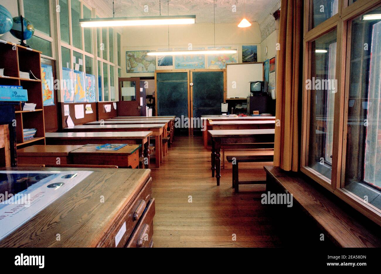 Old Empty Classroom with Wooden Desks and Blackboard Stock Photo