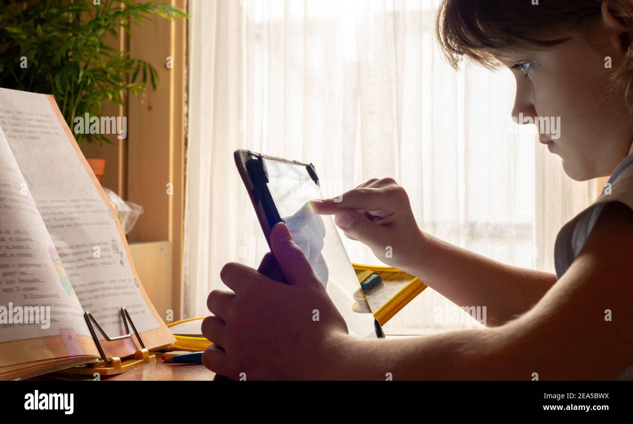 Girl studying online at home using tablet computer Stock Photo