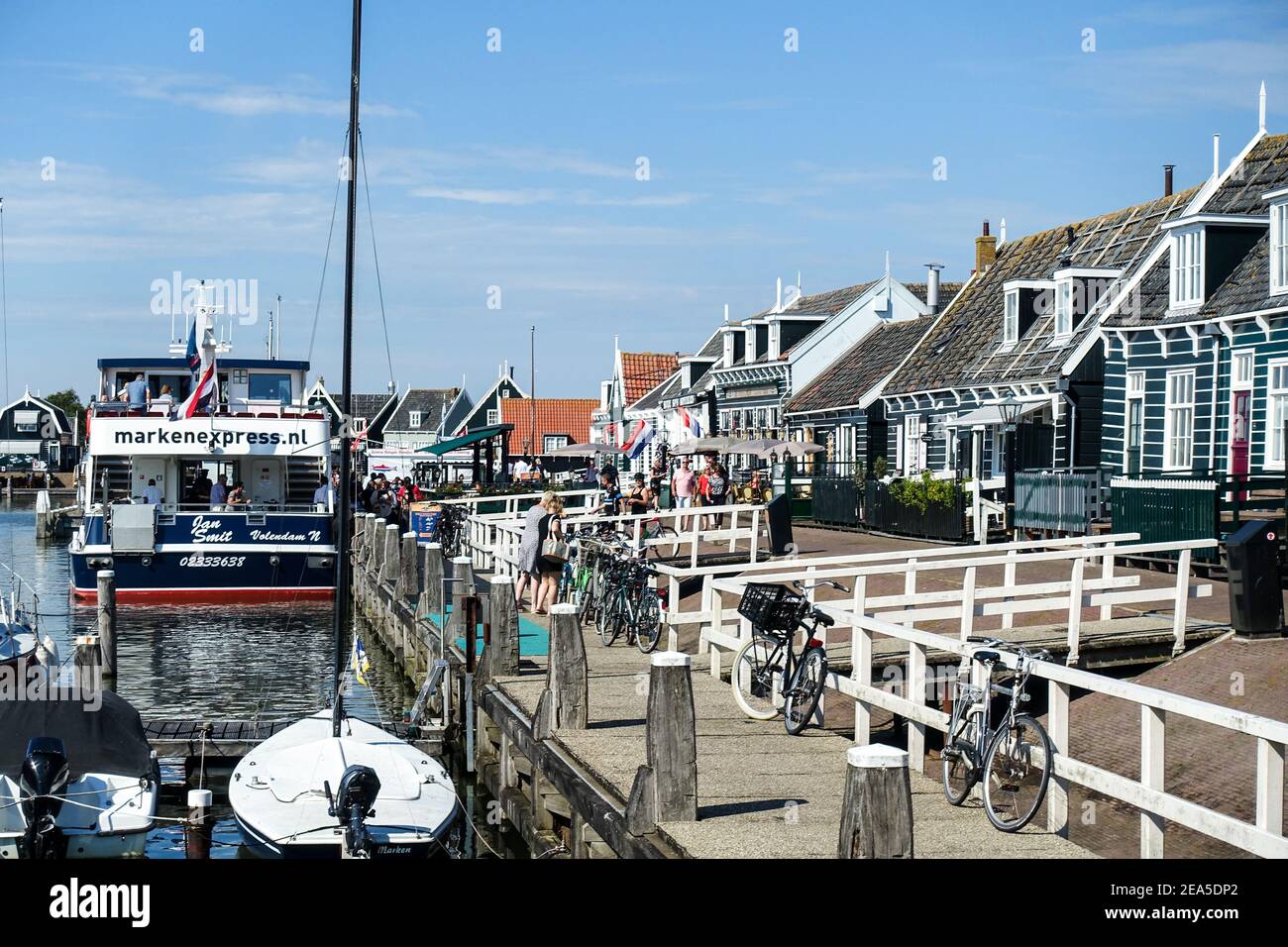 During the pandemic, a few visitors waiting on the quay of the quaint, typical Dutch village and port of Marken, North Holland, Netherlands Stock Photo