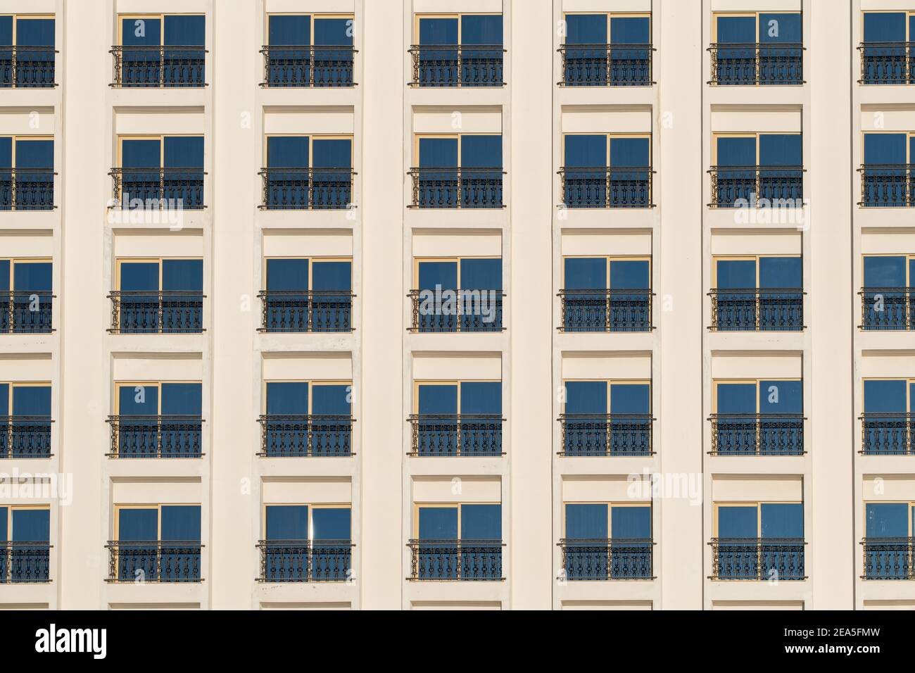 Hotel building facade with many windows on white wall Stock Photo