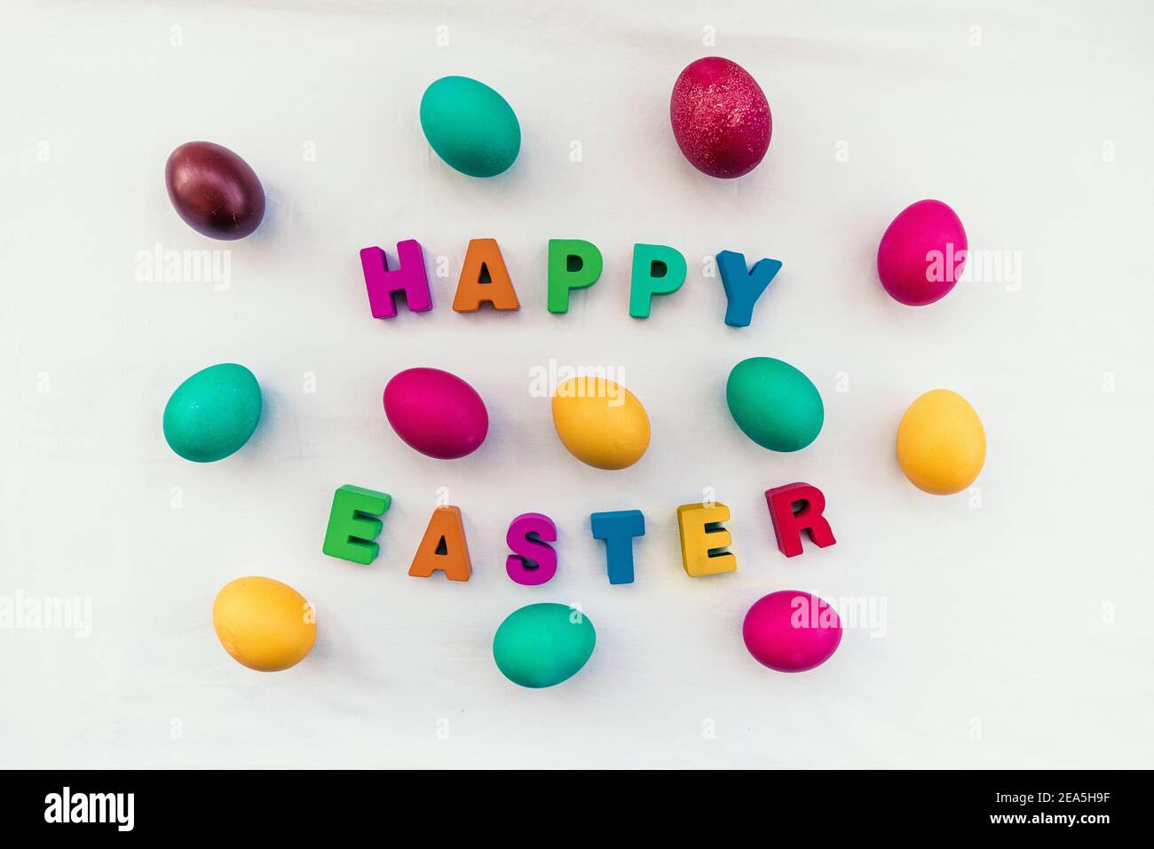 Colored Easter eggs and Happy Easter inscription on the table Stock Photo