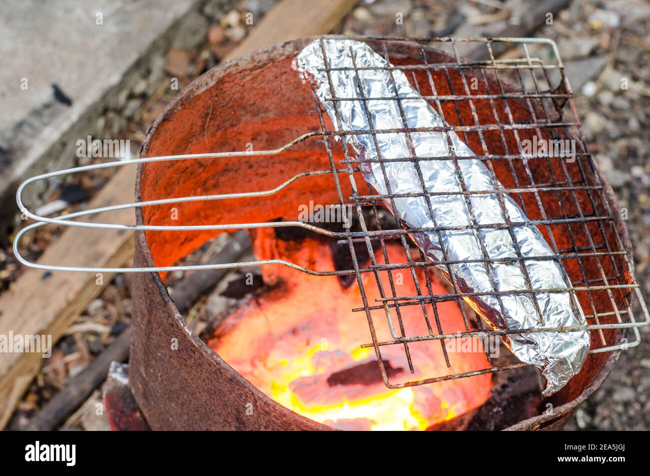 Grilled fish wrapped in foil on the stove Stock Photo - Alamy