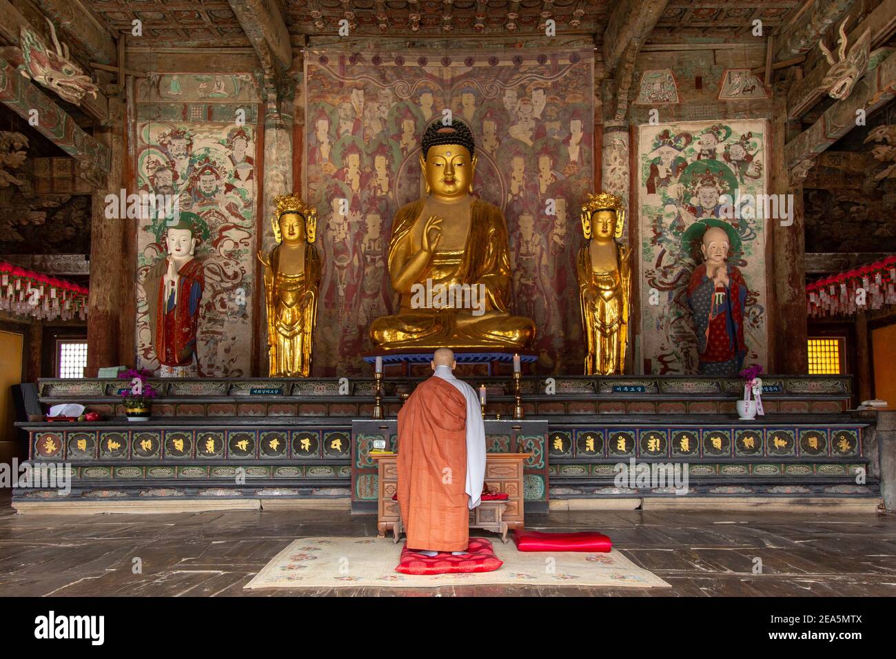 A monk in front of Buddhist statues at Bulguksa temple in Gyeongju, South Korea Stock Photo
