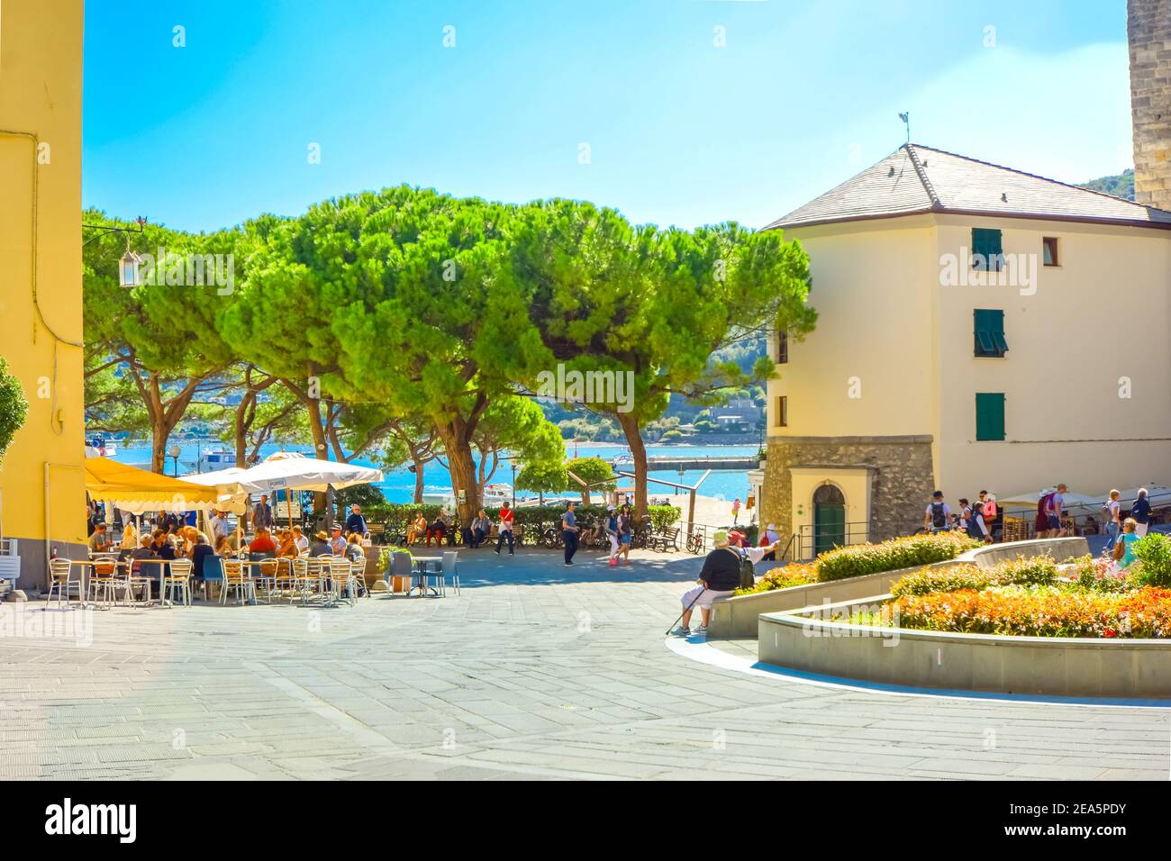 A sunny day on the Ligurian Coast as tourists enjoy cafes and relaxation on the  Piazza Bastreri in the coastal village of Portovenere, Italy Stock Photo