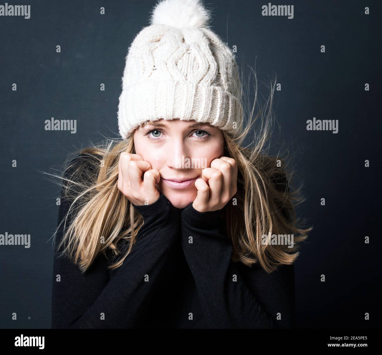 Portrait photography, typical dutch model , white wool hat, dark grey background Stock Photo