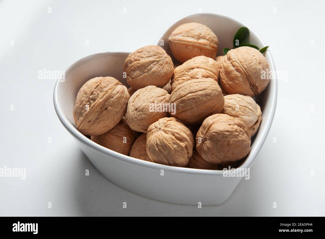 Wallnuts in dark bowl. Healthy vegetarian protein nutritious food. Natural nuts snacks. Stock Photo