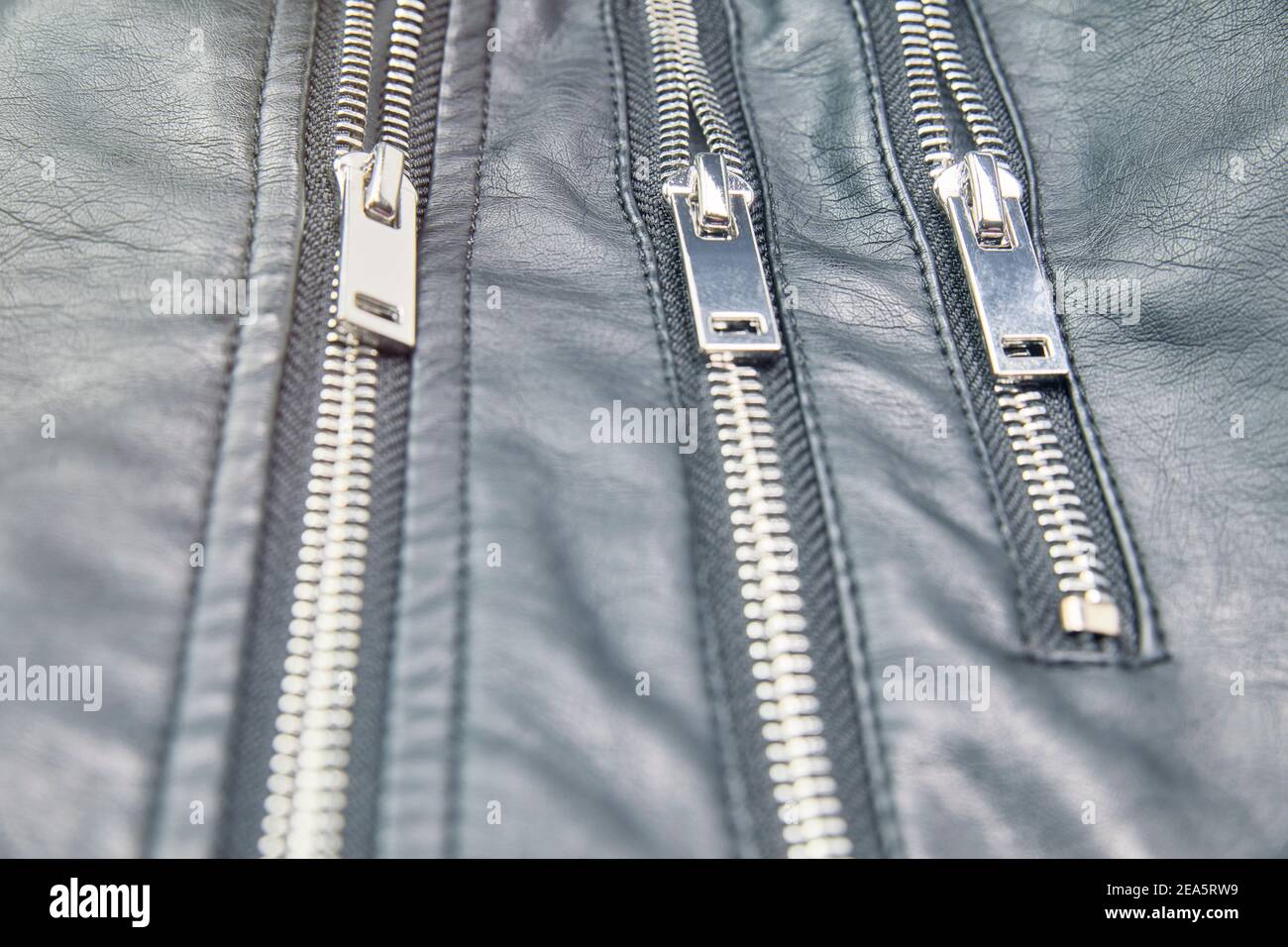 Detail of the metal zippers of the classic black leather jacket. Men