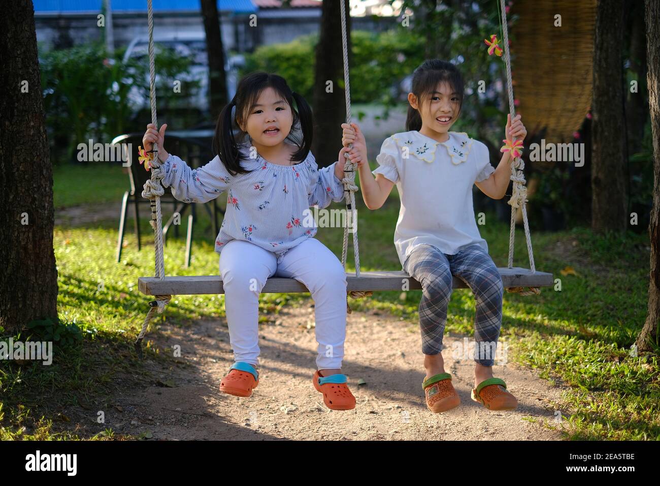 Sisters enjoying by swinging hires stock photography and images Alamy