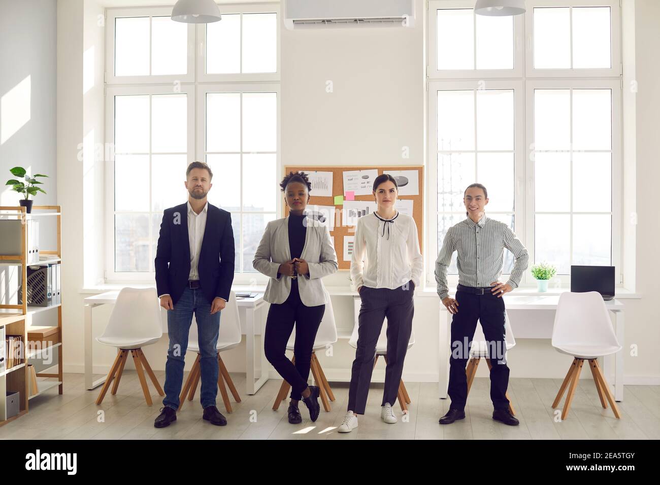 Group of diverse business people standing in modern office and looking ...