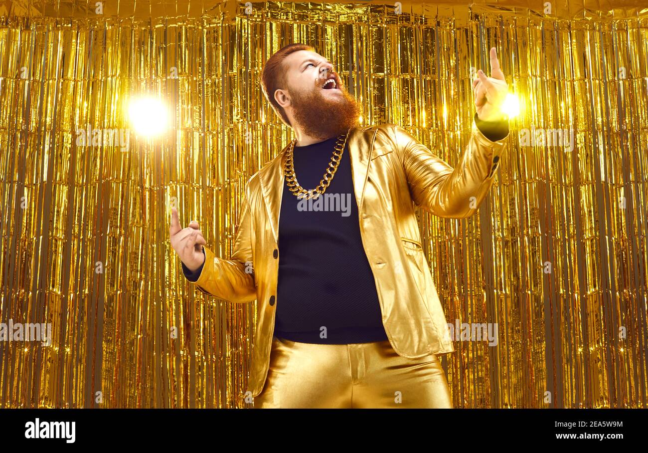 Happy excited bearded chubby man in funny shiny golden suit having fun at disco party Stock Photo