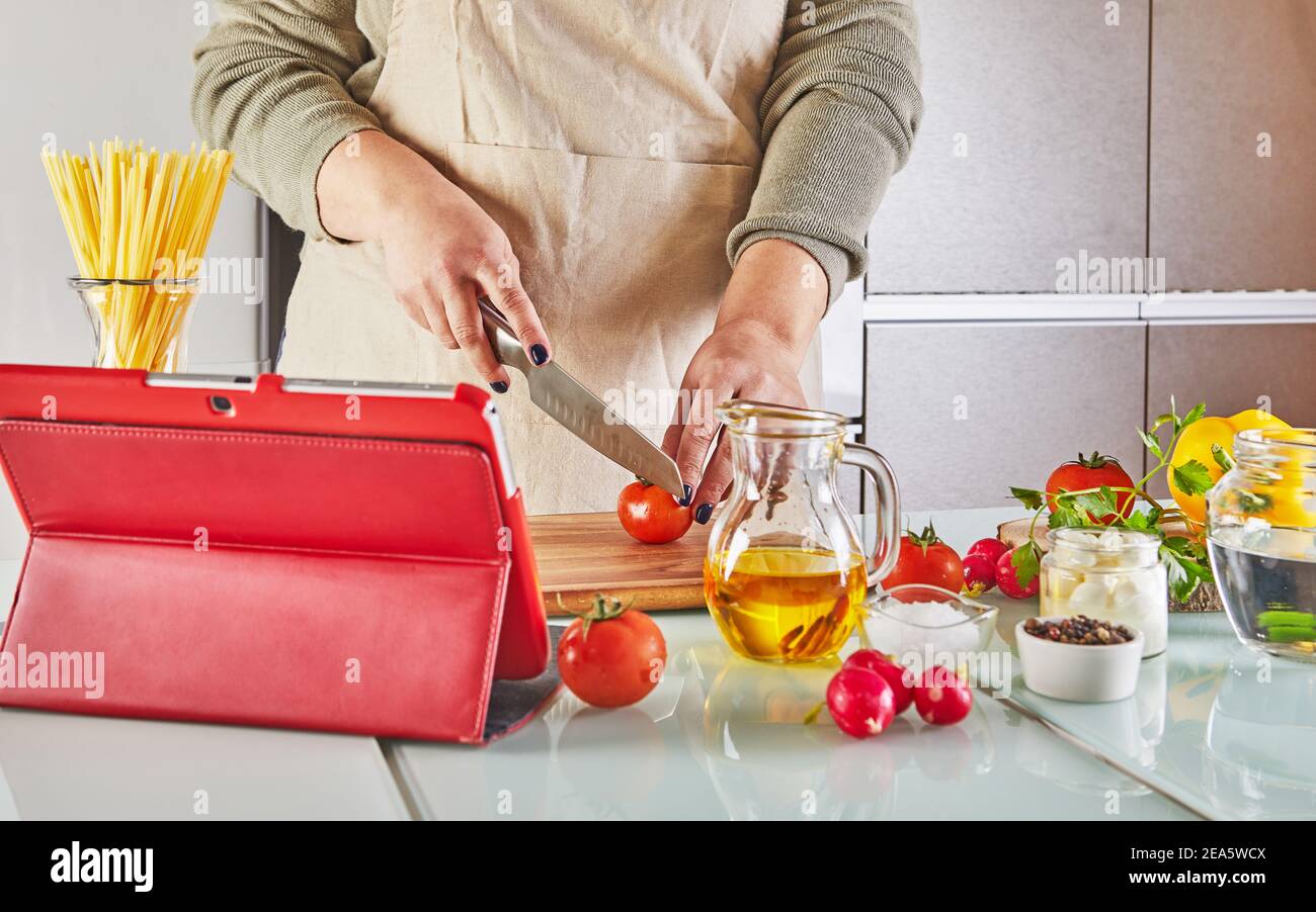 Woman cooking according the tutorial of online virtual master class ...